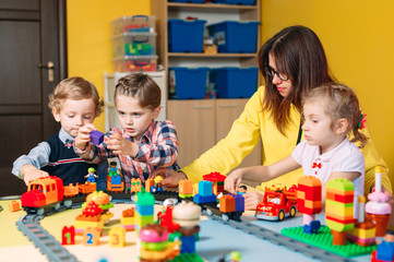 Naklejka premium Educational toys for preschool and kindergarten child. Child playing with constructor blocks at class.