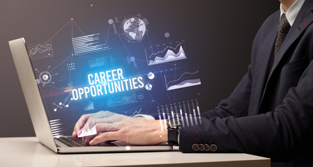 Businessman working on laptop with CAREER OPPORTUNITIES inscription, new business concept