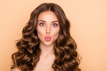 Close-up portrait of her she nice-looking attractive lovely gorgeous cheerful funny well-groomed wavy-haired girl sending air kiss perfect lips line isolated over beige pastel color background - obrazy, fototapety, plakaty