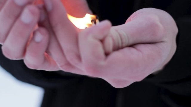 Burning three matches in the male hand. A man holds out a dying matches to the camera