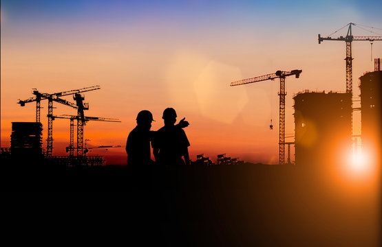 Silhouette of Survey Engineer and construction team working at site over blurred  industry background with Light fair Film Grain effect.Create from multiple reference images together
