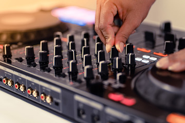 Hands of DJ mixing tracks on professional Dj Mixer