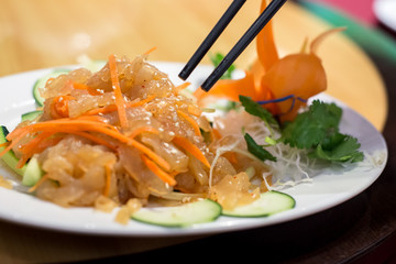 Chinese food on a plate with chopsticks