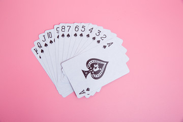 Expanded playing cards on pink background