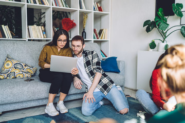 Friends using laptop at home