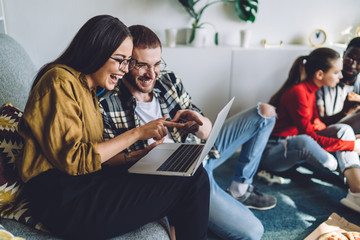 Laughing couple looking at laptop monitor