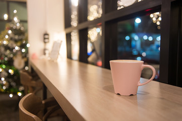 Hot coffee in a cup put on wooden table with christmas theme background