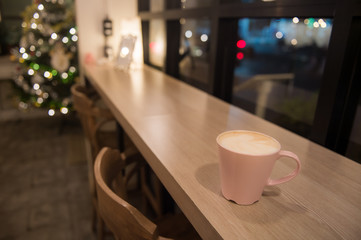 Hot coffee in a cup put on wooden table with christmas theme background