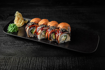 Sushi roll (Maguro) salmon, smoked eel, avocado, philadelphia cheese on black background. Sushi menu. Japanese food.