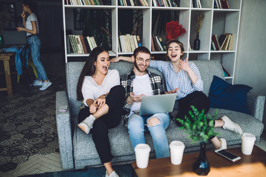 Group Of Young Hipsters Laughing And Sitting On Couch