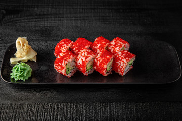 Sushi roll (California Ebi) with shrimp, tobiko, avocado, philadelphia cheese on black background. Sushi menu. Japanese food.