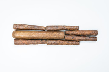 Big and small cigars twisted from sheets of tobacco on white background.