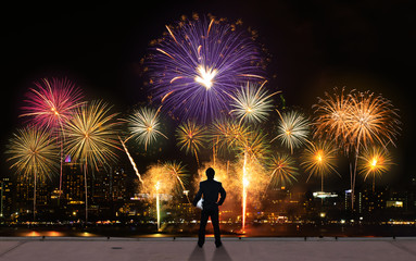 Fototapeta na wymiar businessman stand on roof top of skyscrabber watching fireworks business success conceptual image