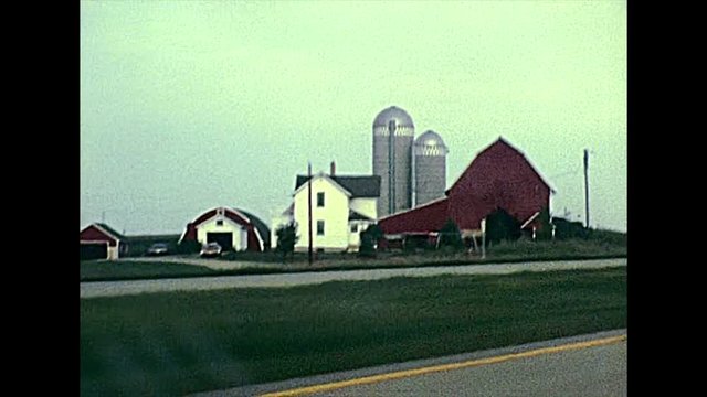 Minnesota State Highway MN 43 in the countryside with local buildings and farms. United States in the 1970s. The historical United States of America.