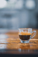 Espresso shot on wood table in cafe shop.