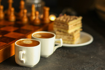 coffee, piece of cake (festive atmosphere, chess, Christmas lights, new year) menu concept. food background. top view. copy space