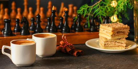 coffee, piece of cake (festive atmosphere, chess, Christmas lights, new year) menu concept. food background. top view. copy space