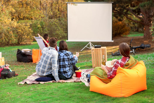 Friends Watching Movie In Outdoor Cinema