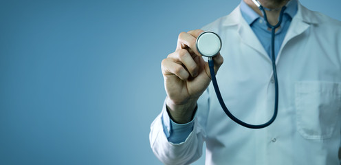 healthcare and medicine - doctor in white coat holding stethoscope on blue background. copy space - Powered by Adobe