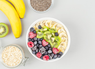 Healthy breakfast smoothie bowl topped with raspberries, blueberries, kiwi, bananas, BlackBerry and seeds chia.  Vegan food. 