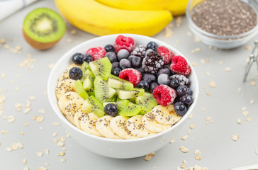 Healthy breakfast smoothie bowl topped with raspberries, blueberries, kiwi, bananas, BlackBerry and seeds chia. Vegan food. 