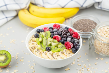 Healthy breakfast smoothie bowl topped with raspberries, blueberries, kiwi, bananas, BlackBerry and seeds chia. Vegan food. 