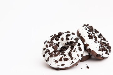 appetizing fresh donuts black and white color with white icing and chocolate chips closeup on a white background