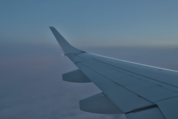 Fototapeta na wymiar wing of an airplane flying above clouds