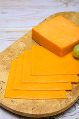 Cheese collection, block and slices of yellow english cheddar cheese