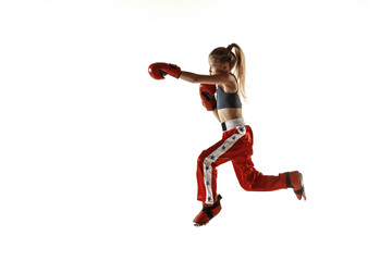Young female kickboxing fighter training isolated on white background. Caucasian blonde girl in red sportswear practicing in martial arts. Concept of sport, healthy lifestyle, motion, action, youth.