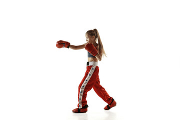 Fototapeta na wymiar Young female kickboxing fighter training isolated on white background. Caucasian blonde girl in red sportswear practicing in martial arts. Concept of sport, healthy lifestyle, motion, action, youth.