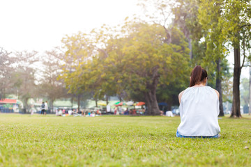 the women is on the grass and beautiful. she is sitting on the grass