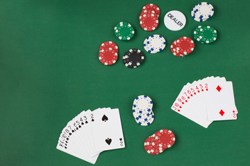 playing card decks, playing chips and dealer chip on a green background