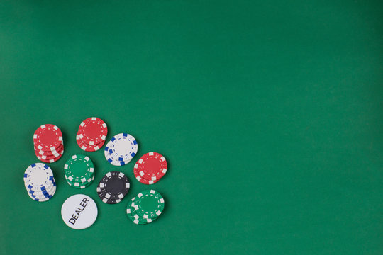 playing chips on a green background and a dealer chip