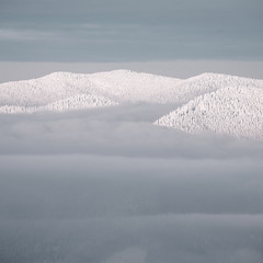 peak of mountains in snow above clouds