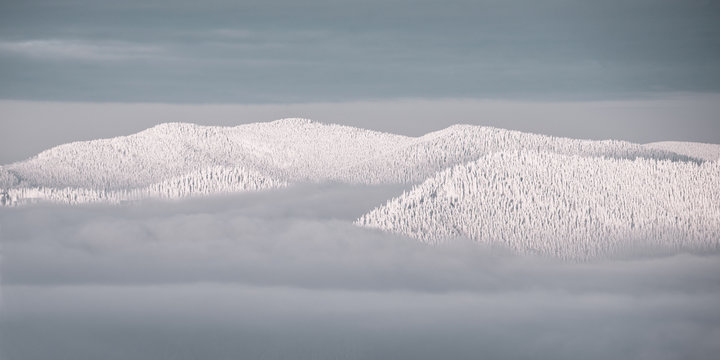 peak of mountains in snow above clouds