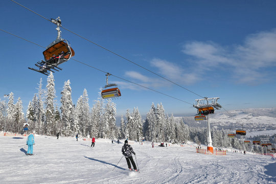 Skiers ski on the ski slope in popular winter resort Kotelnica Bialczanska.