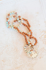 Jewelry mala necklace with natural mineral beads on white wooden decorative background
