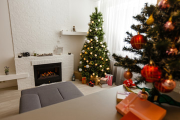 A living room at Christmas time lit only by the fire and Christmas tree.