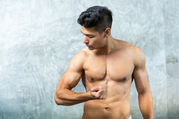 Obraz premium Health care concept, Fitness a man is training to show strong muscle after weight training, Good Healthy Background.