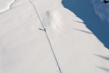 Hiker walking on the snow. Aerial view 