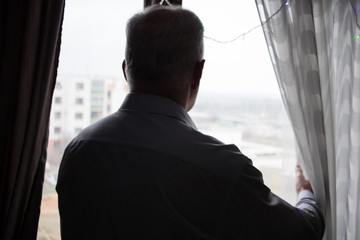 man looking at view from window
