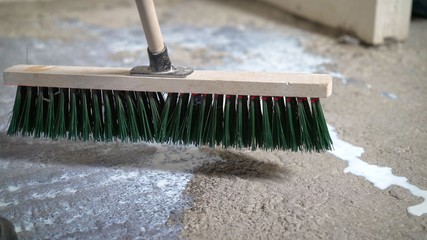 Primer for concrete floor. The master lays liquid soil on a concrete floor. Primer worker on...