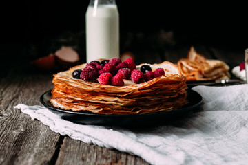 Pancakes on a plate with berries. Breakfast. Maslenitsa