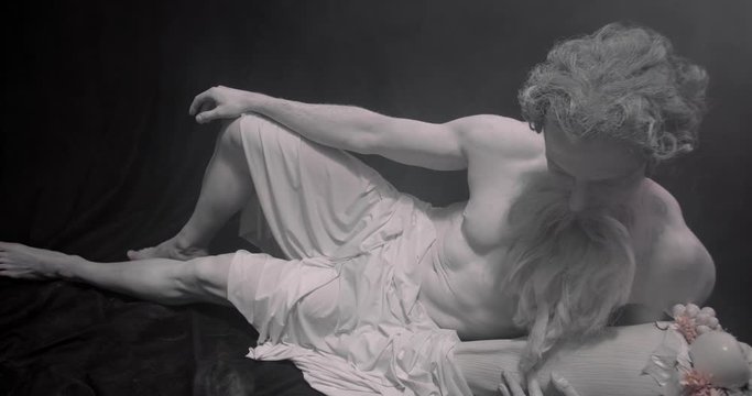 Greek God of wine Dionysus is lying on the floor and looking at the fruit, 4k