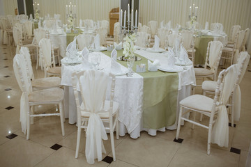 Restaurant decorated with white elements, and tables with crystal dishes.
