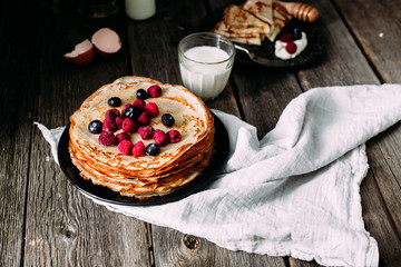 Pancakes on a plate with berries. Breakfast. Maslenitsa