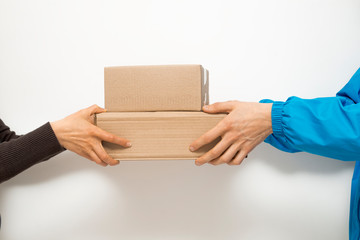 Hands of a delivery courier pass the packaging to the customer.