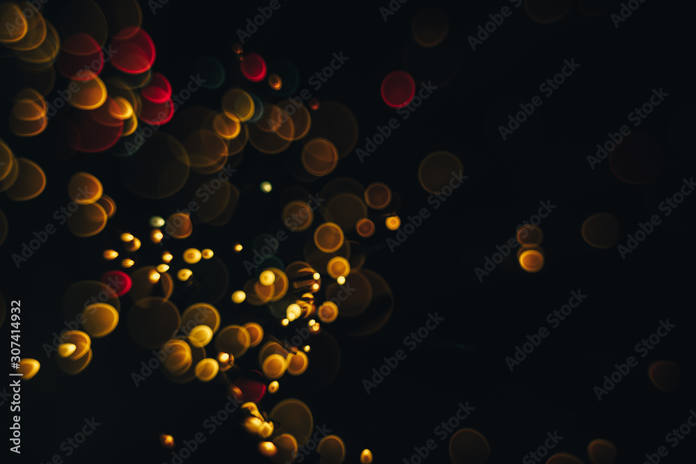 Poster beautiful magic gold and red bokeh background in the darkness.