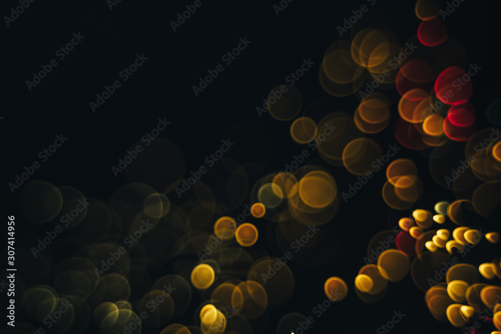 Poster beautiful magic gold and red bokeh background in the darkness.